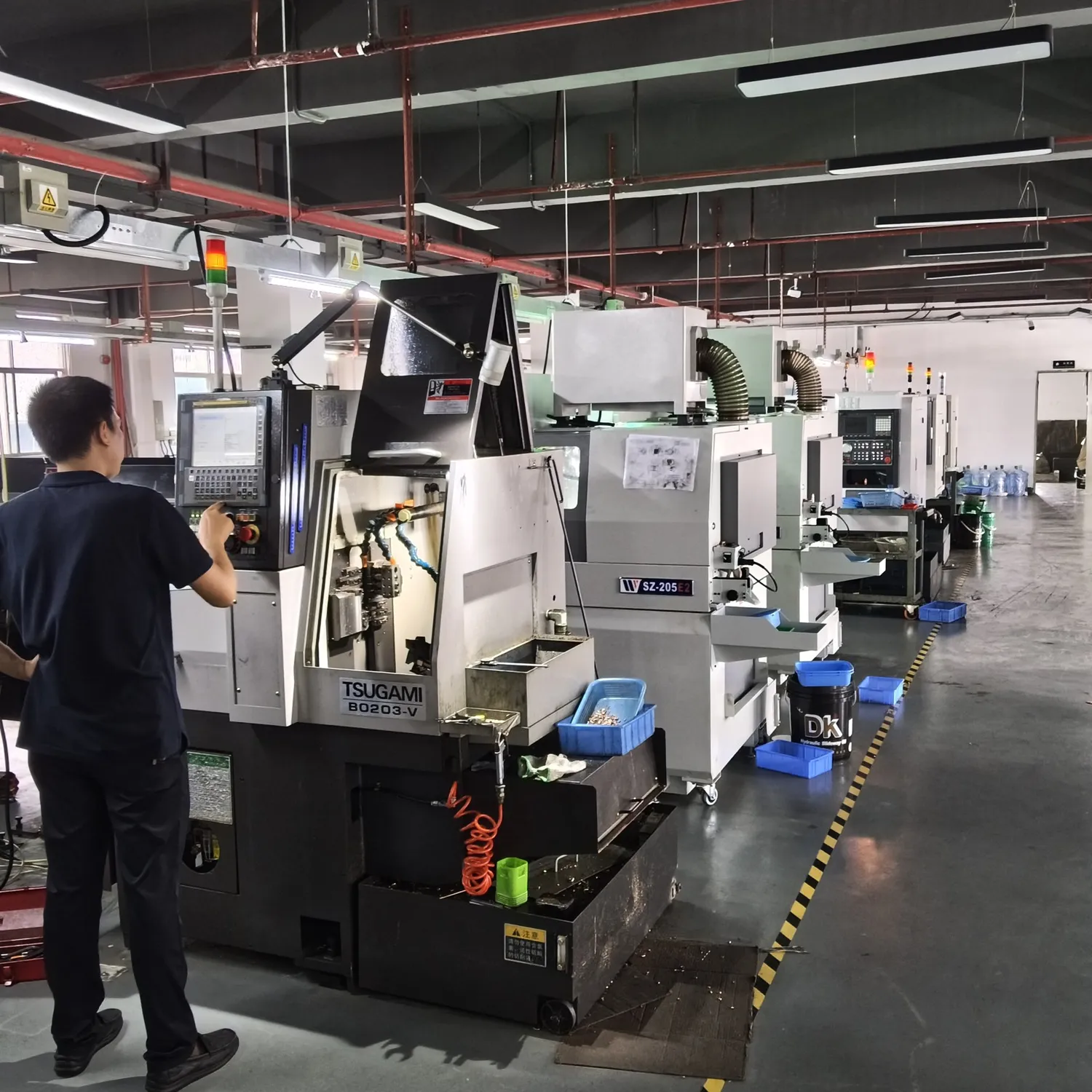 Operator working beside CNC machinery in the Rui'an factory